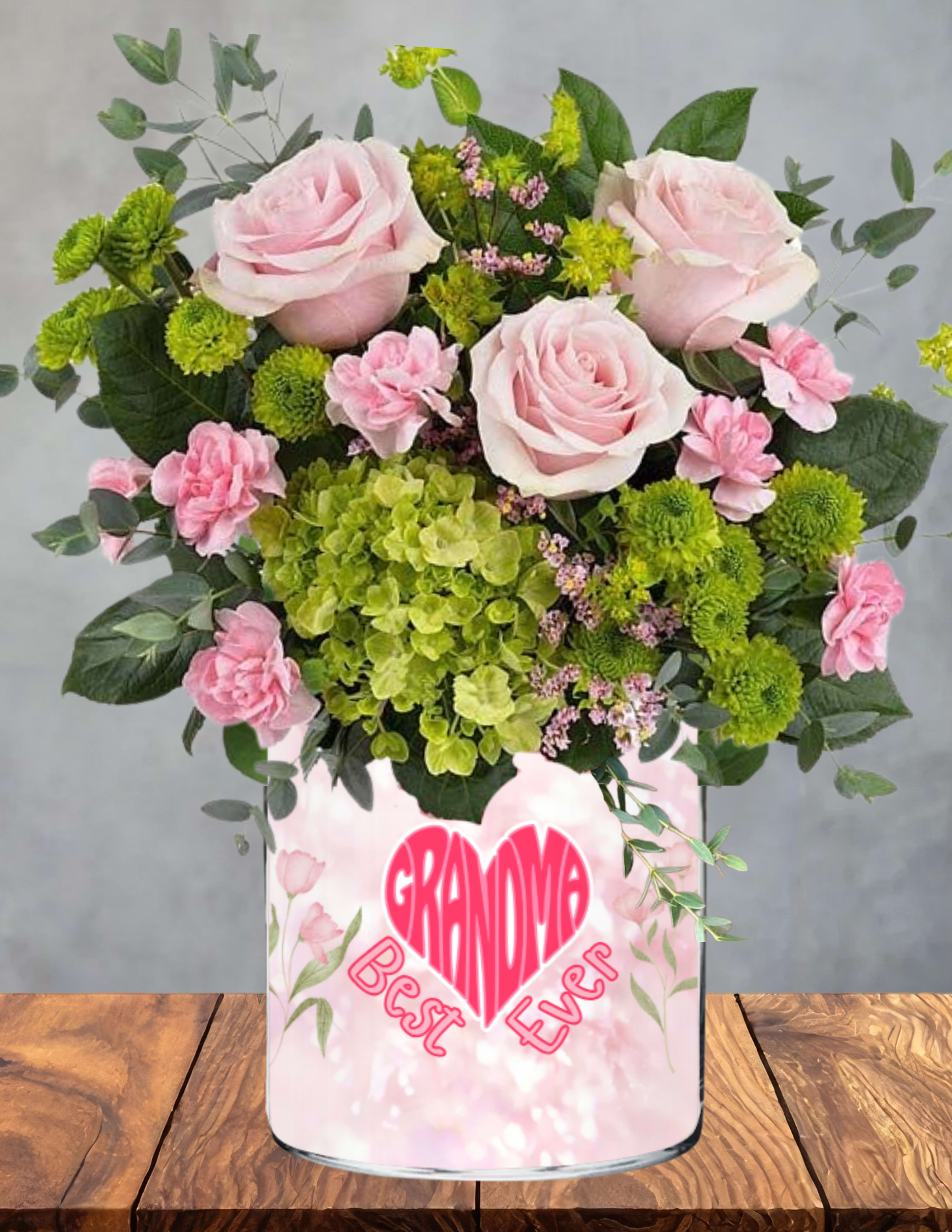 Grandmas sweet meadow - A gentle garden of love, gathered just for the one who makes every moment sweeter.  Grandma’s Sweet Meadow blends blush roses, soft pink carnations, fresh green hydrangeas, and cheerful button blooms into a pastel‑kissed arrangement that feels calm, comforting, and full of affection. Each flower adds its own whisper of gratitude — for her kindness, her warmth, and the way she makes family feel like home.  Nestled among the blooms is a charming heart accent celebrating her as the “Best Ever,” a keepsake she’ll treasure long after the flowers have faded. Presented in a playful, pastel‑patterned vase made just for Grandma, this design radiates joy, tenderness, and that unmistakable grandmotherly love.  A perfect way to remind her how cherished she truly is.