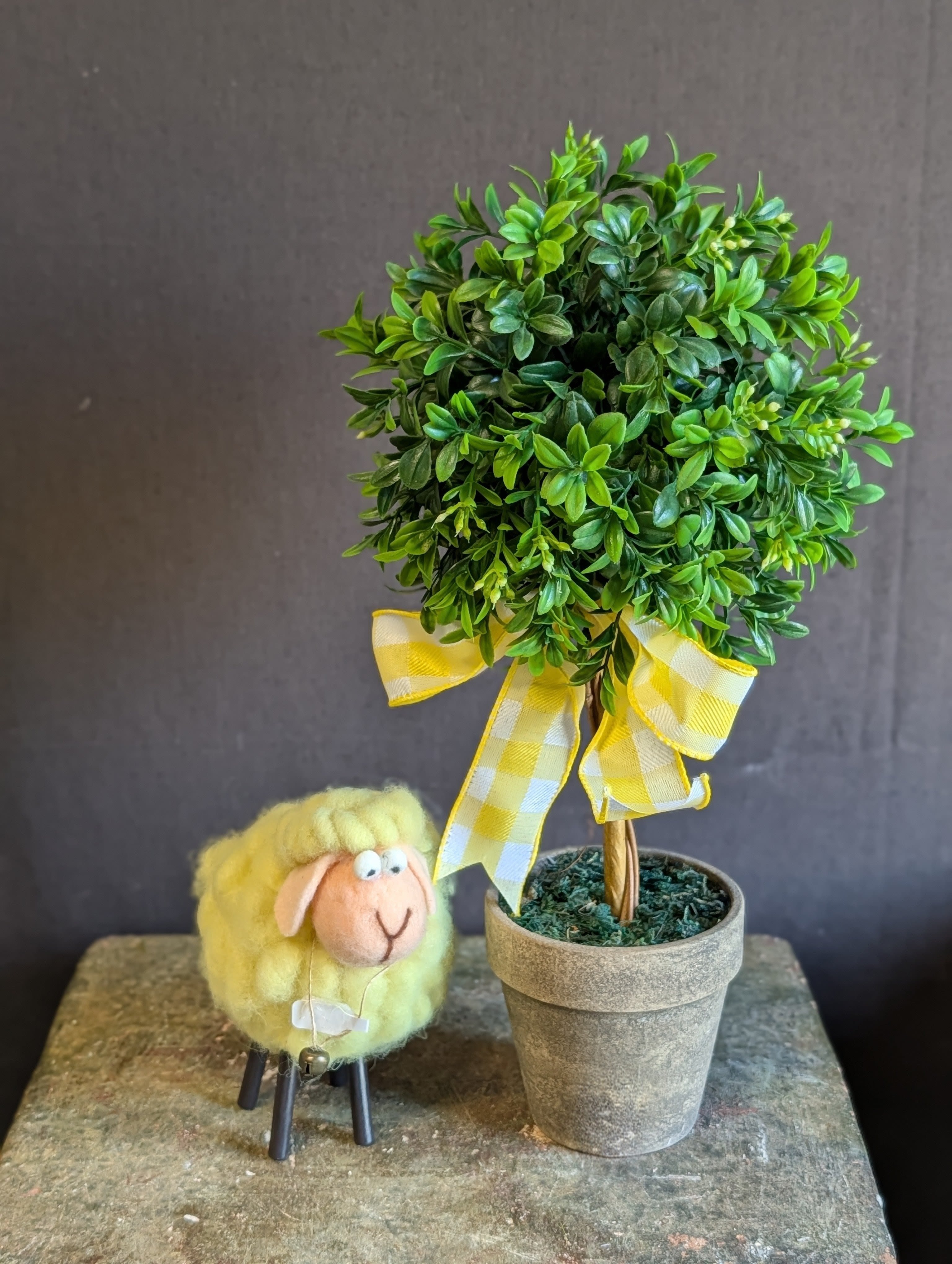 Sunny the Lamb &amp; His Topiary  - Bring Easter cheer to your home with this petite silk boxwood “lollipop” tree, accented with a sunny yellow gingham bow and a playful yellow lamb figurine complete with bell necklace. Perfect for mantels, desks, or tabletops, it’s a low‑maintenance, high‑charm gift that celebrates the joy of spring.