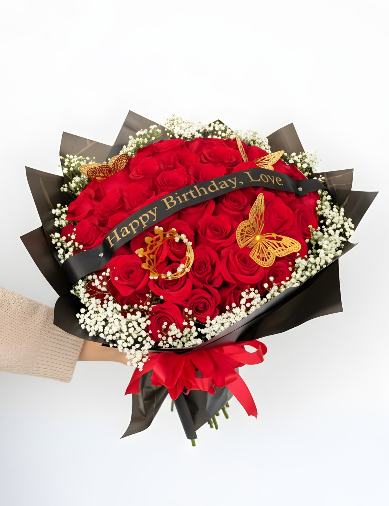 Golden Love Luxe - A luxurious expression of love and celebration, this stunning bouquet features an abundant collection of 50 rich red roses, beautifully wrapped in sleek black paper and finished with elegant gold accents. Delicate baby’s breath adds softness and texture, while decorative butterflies and a crown detail create a truly regal presentation.  Perfect for birthdays, anniversaries, or any unforgettable moment, this arrangement is designed to make a bold and lasting impression. The striking contrast of red, black, and gold gives it a modern, upscale feel that speaks of passion, elegance, and thoughtfulness.  Finished with a custom message ribbon, this bouquet is more than flowers—it’s a statement of love, celebration, and luxury. Please note that the message can be customized. Please indicate in the Florist Instructions box