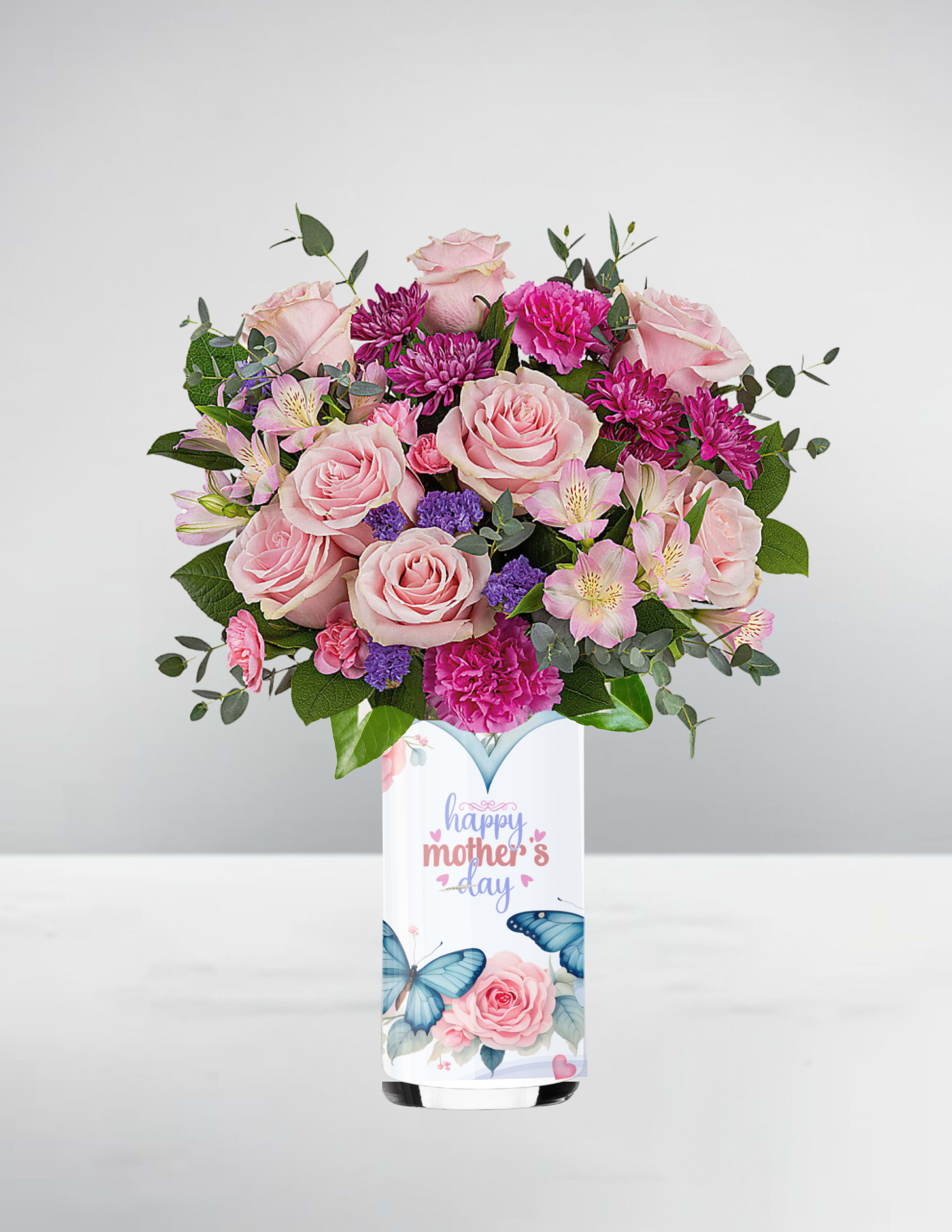 Pink and purple mixed bouquet in a tall white butterfly vase with 'happy mother's day' text