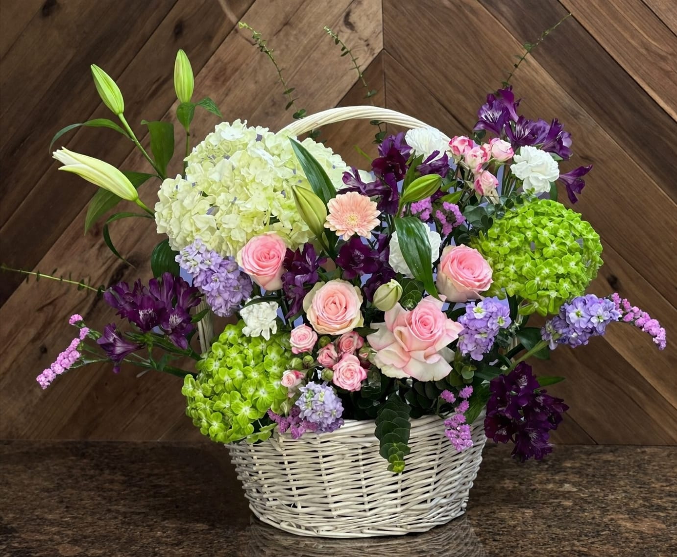 Garden Elegance Spring Basket – Hydrangea &amp; Rose Floral Arrangement - Bring the beauty of a blooming garden indoors with our Garden Elegance Spring Basket. This handcrafted floral arrangement is designed in a charming white wicker basket and features a premium mix of fresh flowers including soft pink roses, vibrant green hydrangeas, delicate stock, lilies, alstroemeria, and seasonal accent blooms.  Designed with a natural, airy garden style, this arrangement is perfect for birthdays, anniversaries, get well wishes, or simply to brighten someone’s day. The combination of soft pastels and rich purples creates a balanced, elegant look that feels both cheerful and sophisticated.  At AZ Flowers &amp; Gifts LLC, we specialize in high-quality, handcrafted floral designs with same-day flower delivery in Alpharetta, GA 30022. Each arrangement is made fresh to order and may vary slightly to ensure the best seasonal blooms are used.