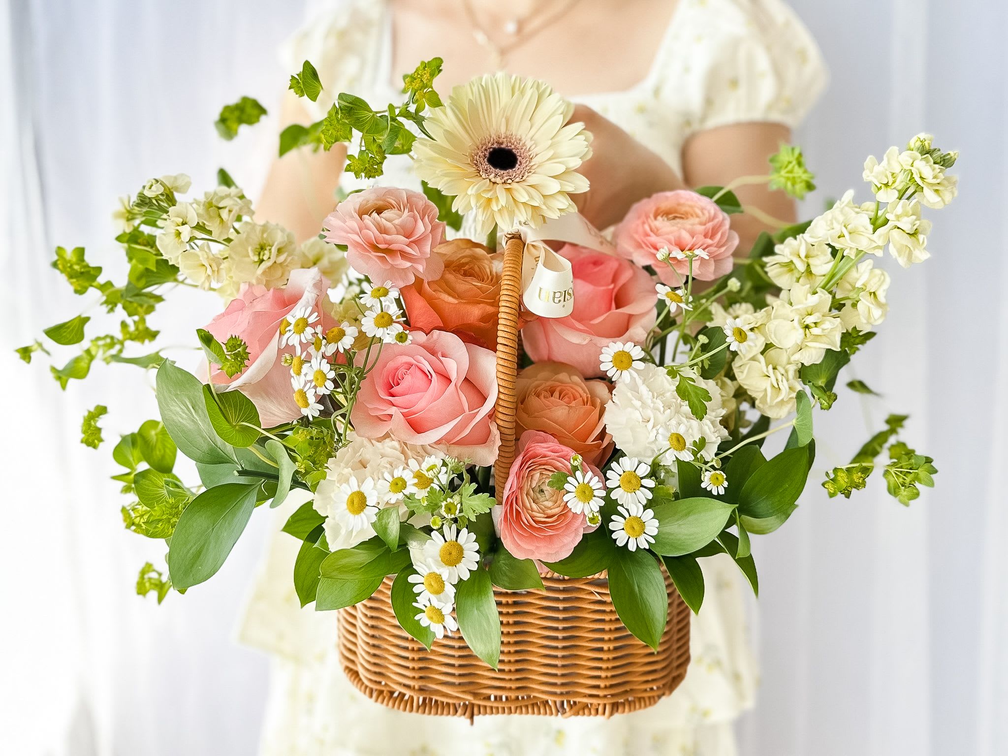 Garden Delight Basket - This beautiful flower basket captures the essence of a blooming garden, featuring a harmonious mix of colors in pink, yellow, and citrus hues. Nestled in a charming, rustic basket, this garden-style arrangement exudes natural beauty and elegance. It's the perfect gift for any occasion, from birthdays and anniversaries to brightening someone's day.  Disclaimer  Flower varieties and exact shades may vary based on seasonal availability. Substitutions may be made while maintaining the overall color palette, style, and value of the arrangement to ensure the freshest blooms and the highest design quality.