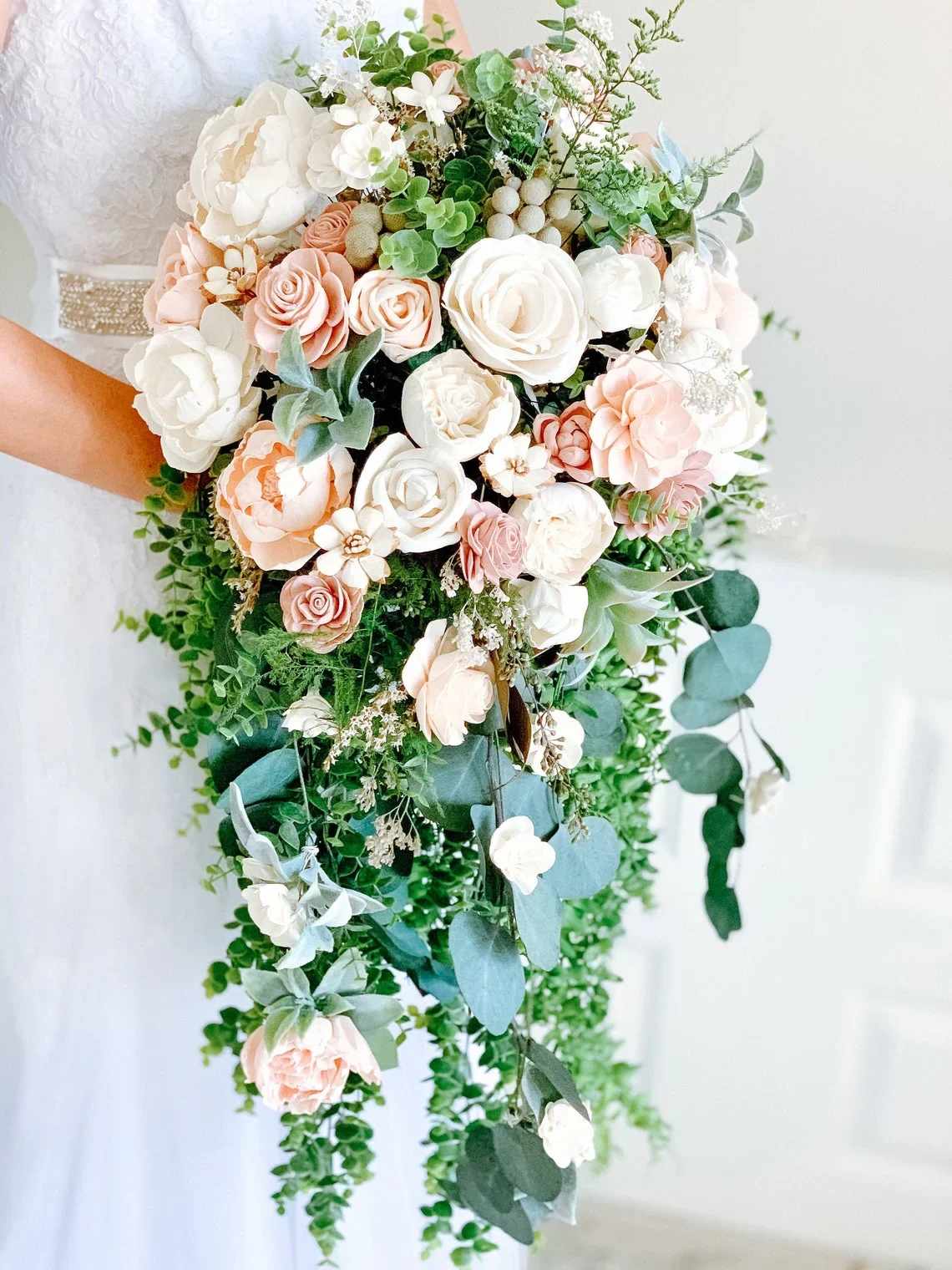 Cascading bridal bouquet of white and blush roses and peonies with trailing greenery