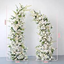 Tall asymmetrical white floral pillars forming an open wedding arch.
