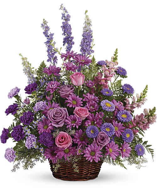 Gracious Lavender Basket - Soothing lavender, respectful purple and compassionate pinks are combined beautifully in this basket overflowing with pretty flowers, sincerity and sympathy. A lovely way to share your thoughts and pay tribute to someone special. A profusion of purple, pink and lavender blooms such as roses, carnations, larkspur, matsumoto and monte cassino asters and much more are delivered in a round wicker basket. Orientation: One-Sided