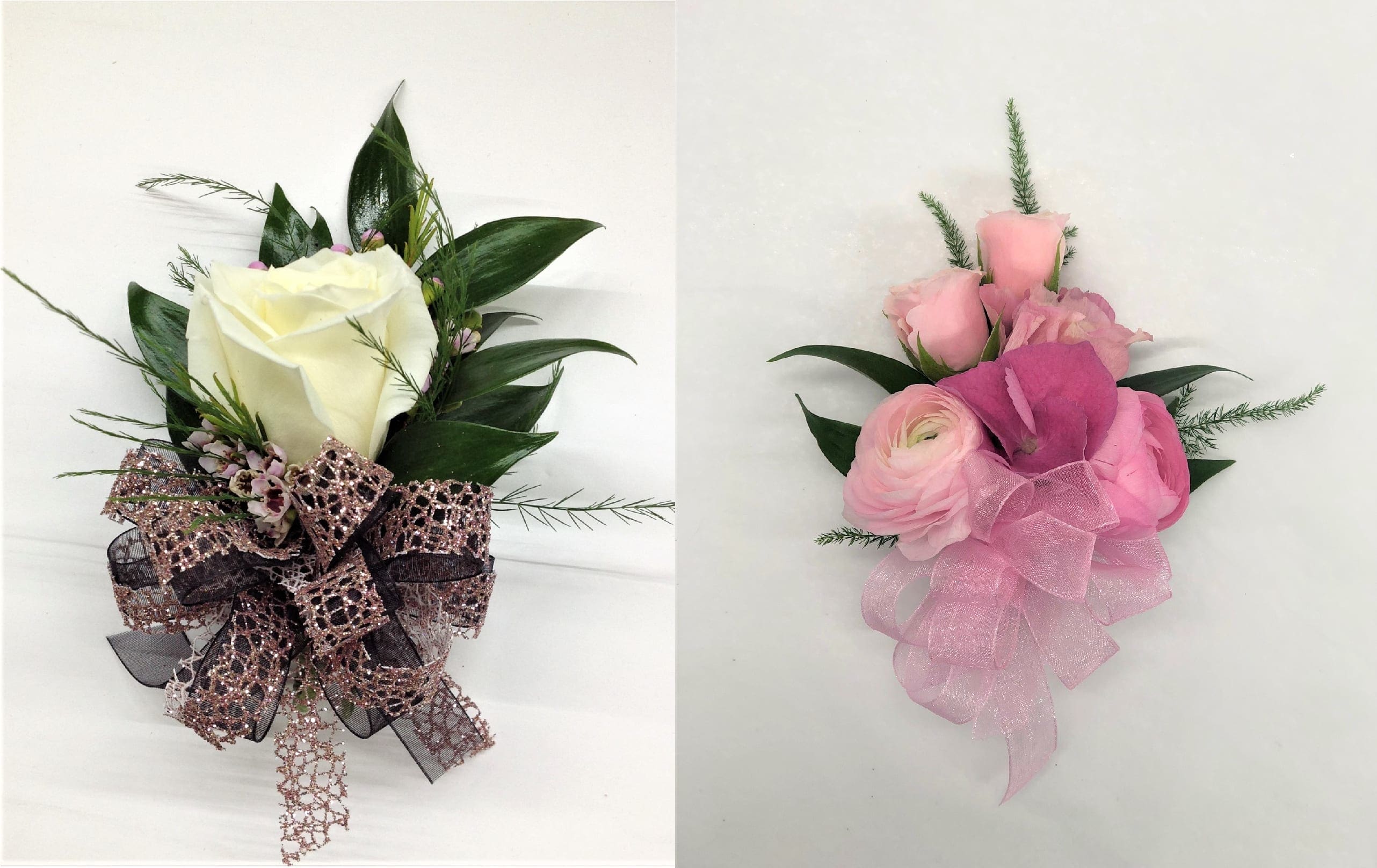 Two corsages with white and pink roses accented with decorative ribbons