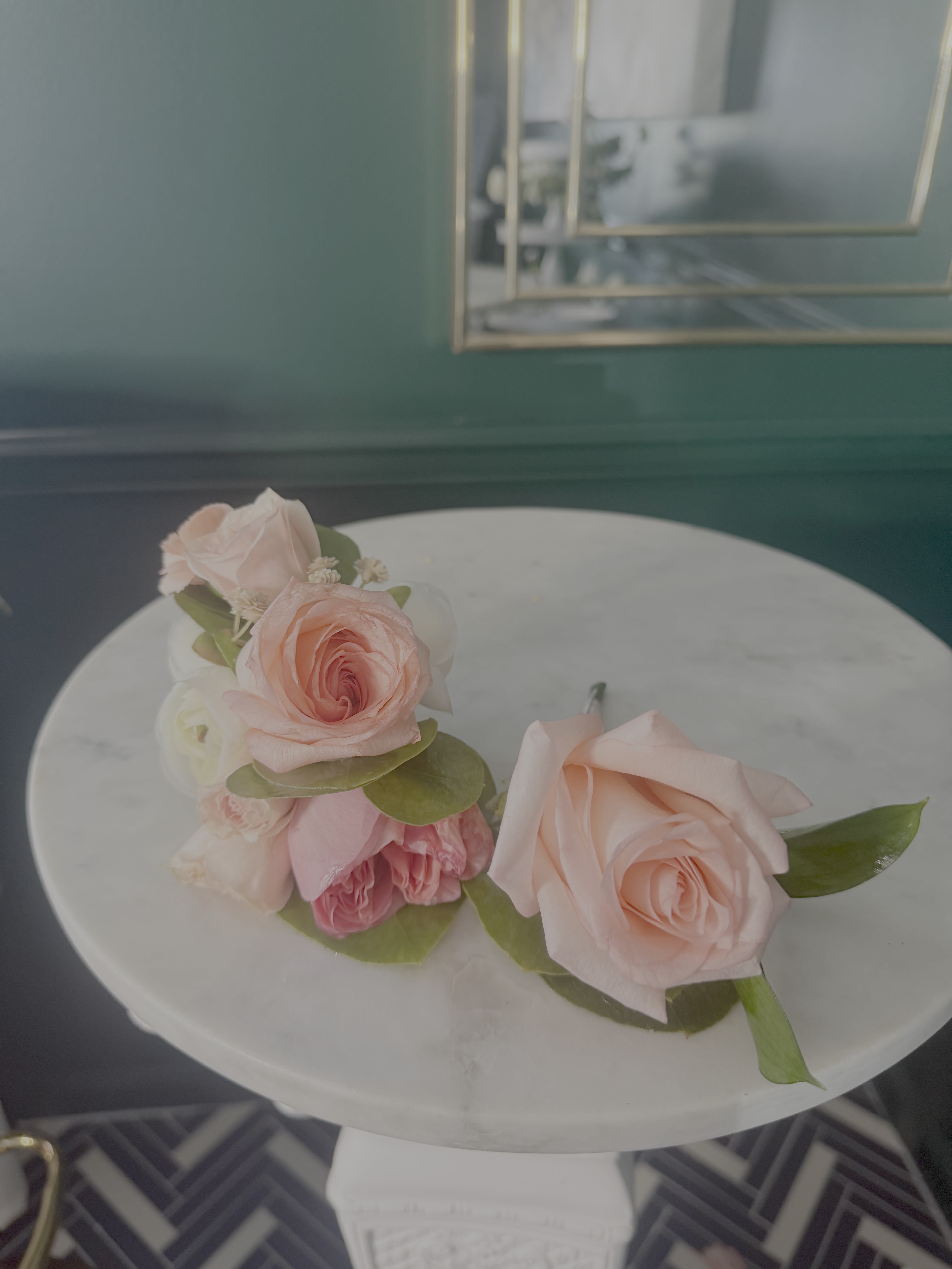 CLASSIC BOUTONNIERE  - Typically worn on a lapel, it consists of a single rose bud. It is accented with deep green leaves (often Israeli Ruscus or Eucalyptus) and secured with a pin. 