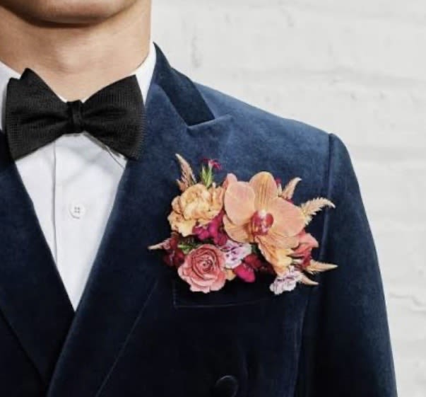 POCKET SQUARE BOUTONNIERE - A modern, pocket square boutonniere featuring a premium rose accented with delicate filler blooms and layered  detailing. Designed for a sleek, high‑contrast look, this piece blends classic romance with contemporary style. This photographs beautifully for