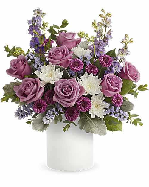 Playfully Yours - A playful spin on the classic rose bouquet, these lovely lavender blooms look fun and flirty in this frosted white glass jar. Lavender roses, purple button spray chrysanthemums, white cushion spray chrysanthemums, &amp; lavender larkspur