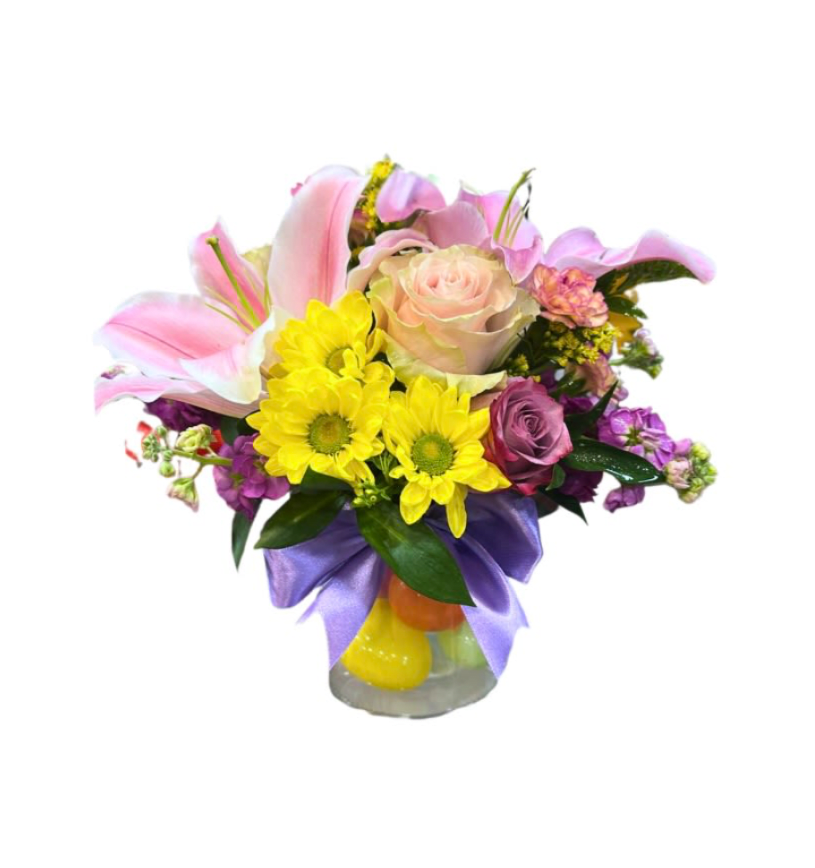 Joy Floral Vase - Celebrate life’s joyful moments with our Joy Floral Vase. This vibrant arrangement features soft pink lilies, blush and lavender roses, and cheerful yellow blooms, thoughtfully designed in a clear glass vase.  A fresh and colorful design perfect for birthdays, baby showers, celebrations, or simply to brighten someone’s day.  Designed with care. Flower varieties and colors may vary slightly while maintaining the overall look and feel.