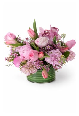 A Mother's Love Bouquet - A soft and romantic arrangement featuring lush pink peonies, roses, tulips and delicate seasonal blooms, artfully gathered in a modern green vase. Designed with airy texture and fresh spring tones this piece brings effortless elegance to any space.