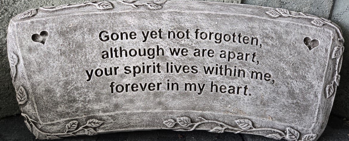 Rectangular gray memorial stone with heart cutouts and engraved verse about remembrance and love.