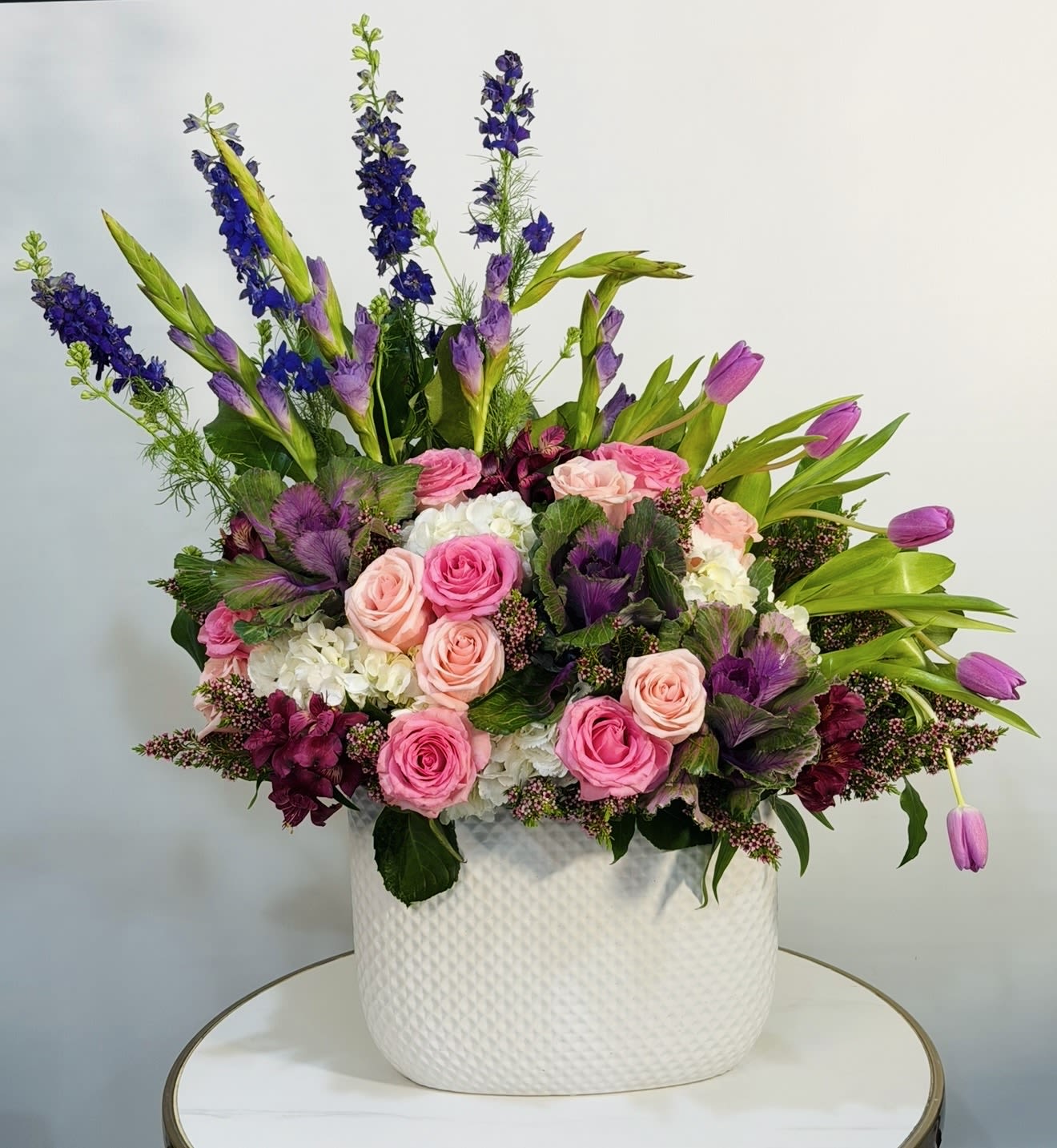 Wild Romance - A bold and expressive floral arrangement featuring premium pink roses, elegant tulips, lush hydrangea, and seasonal blooms in rich shades of pink, purple, and fresh greens all beautifully designed in a modern ceramic vase. Wild Romance is designed to capture emotion and movement, combining soft romantic tones with a vibrant, garden inspired feel. Perfect for birthdays, anniversaries, celebrations, or when you want to make a lasting impression. Each arrangement is handcrafted using fresh, high quality flowers, creating a full, luxurious look with natural texture and depth. We offer same day flower delivery across Beverly Hills, Bel Air, West Hollywood, Beverly Grove, Studio City, Sherman Oaks, Encino, Hollywood, Hollywood Hills, Culver City, Santa Monica, Venice, Marina Del Rey, Topanga and nearby areas. Order today for fast, reliable same-day flower delivery and a stunning floral experience.