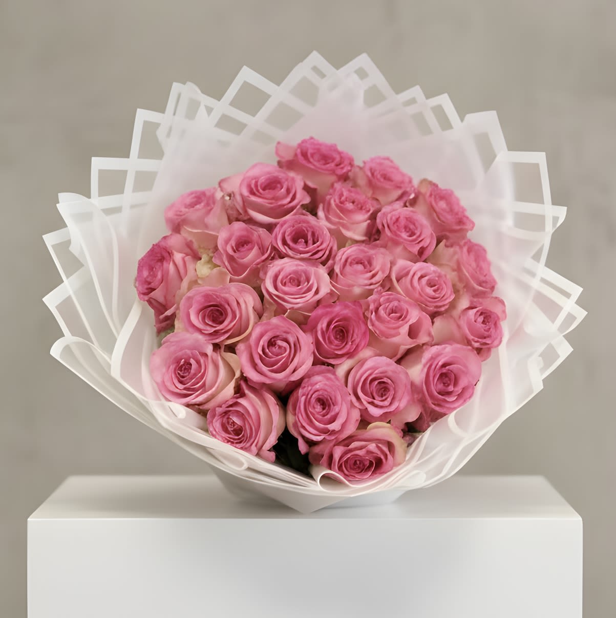 Large bouquet of pink roses wrapped in layered white translucent paper