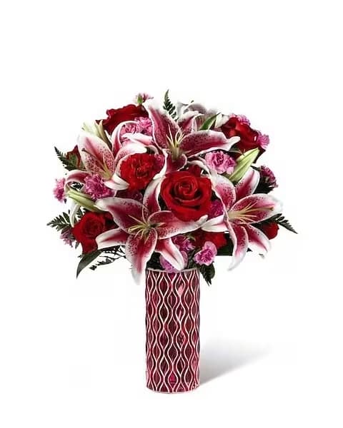 Lasting Romance - A love that defies the bounds of time, this gorgeous Valentine flower bouquet has been designed to express your heart's every emotion. Rich red roses and exquisite Stargazer Lilies are truly fascinating surrounded by red carnations, pink mini carnations and lush greens. Presented in a keepsake mosaic red and pink glass vase with a modern pattern, this romantic flower bouquet is set to make you special someone's heart beat a little faster. 