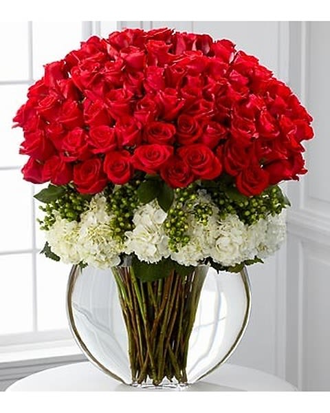 Lavish Luxury Bouquet - Lavish your special someone with a bouquet that will leave them breathless. Silky red premium long-stemmed roses offer a message of passionate love and affection arranged amongst a bed of white hydrangea blooms elegantly accented with clusters of green Hypercom berries. Arriving in a superior clear glass pillow vase, this luxurious bouquet will leave a lasting impression. Standard 3 doz roses Deluxe 4 doz roses Premium 5 doz roses 