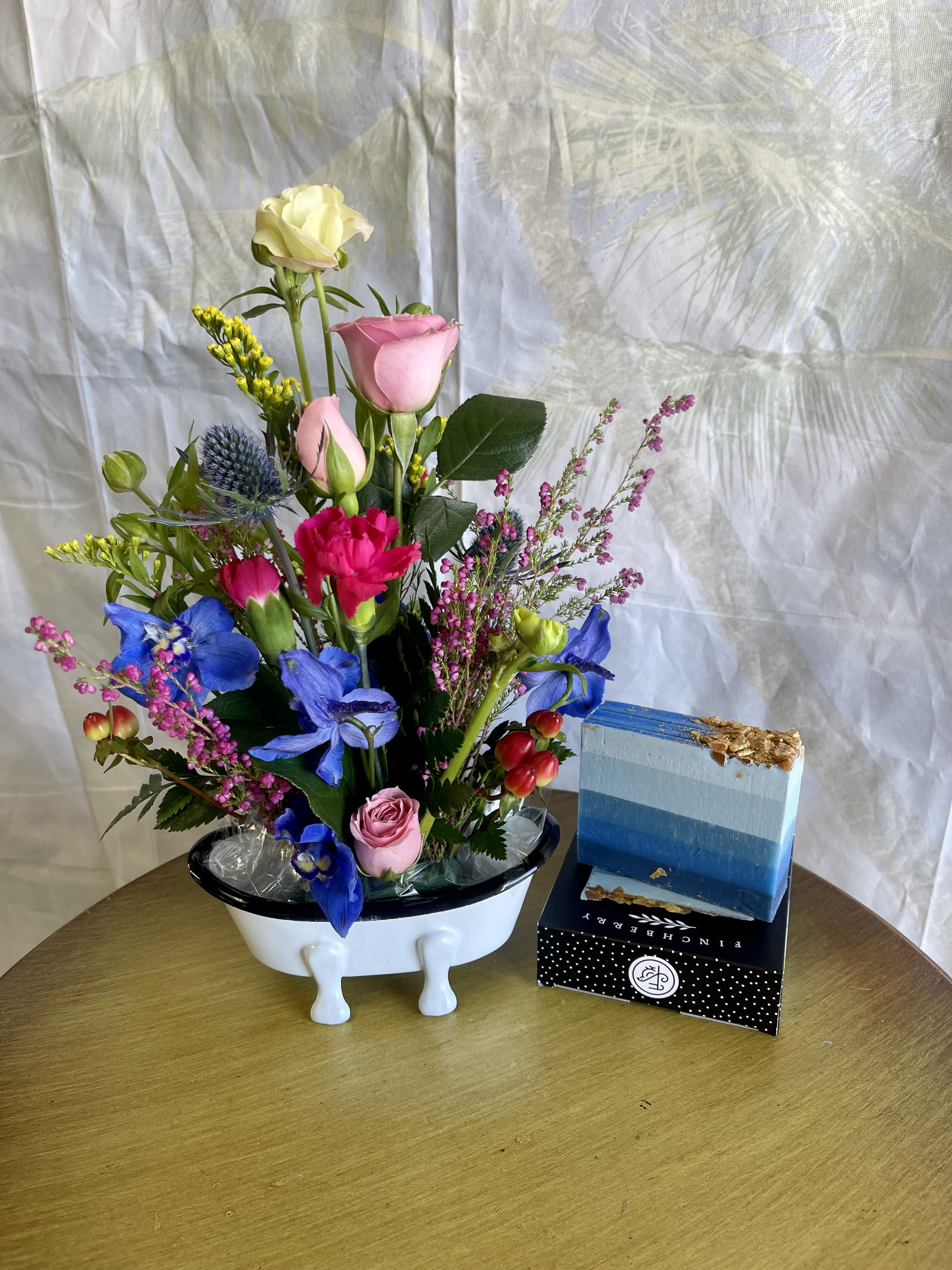 Mixed bouquet in a white vase with pink, blue, and yellow flowers