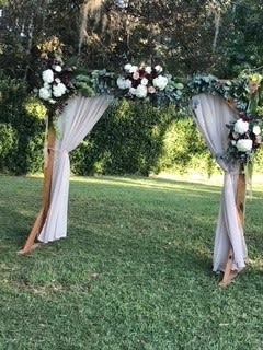 Wooden Arch with Flowers and Greenery Garland - Wooden arch adorned with greenery garland, draping and three large swags.  Price includes set up and removal. Perfect for backyard wedding backdrop.