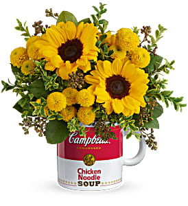 Yellow sunflowers and button mums arranged in a red and white Campbell's soup mug