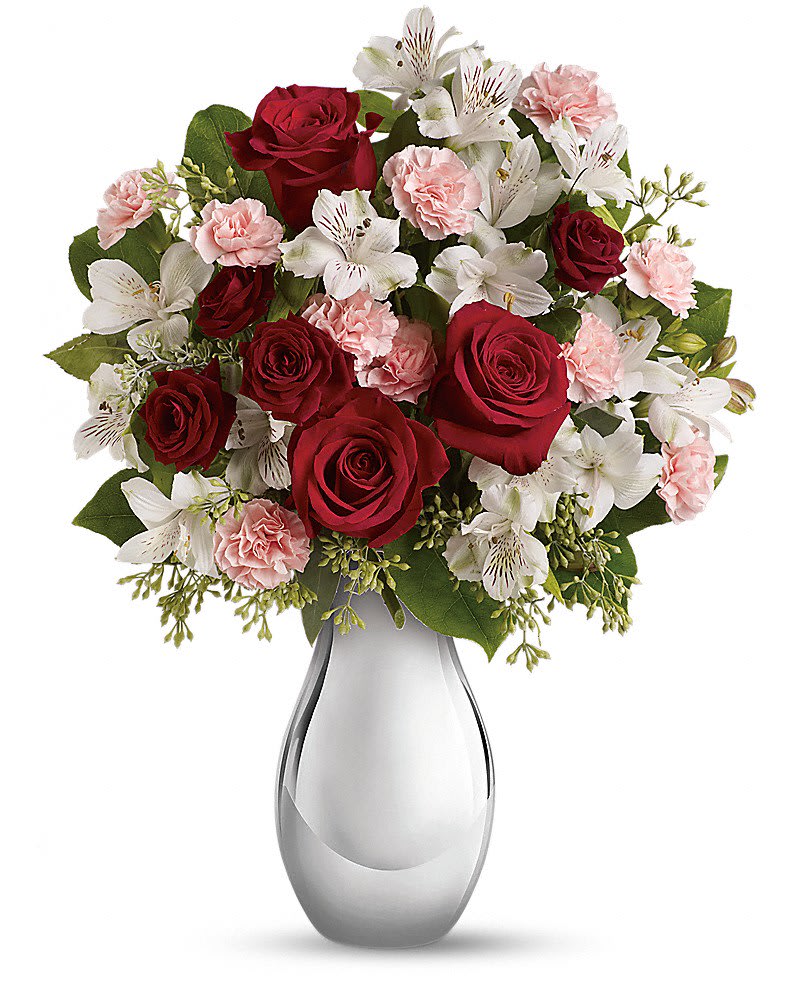 Arrangement of red roses, white alstroemeria, and light pink carnations in a shiny silver vase