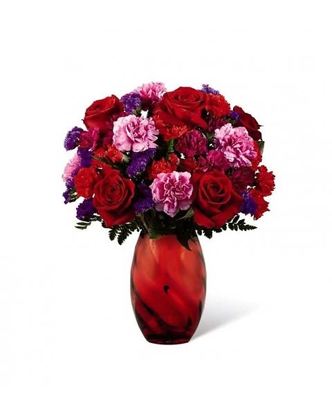 Sweethearts Bouquet - The perfect expression of love and sweet affection, this Valentine's Day bouquet is ready to send your heart's every wish straight to your recipient's door with blooming beauty. Rich red roses are surrounded by a collection of ruffled blooms including hot pink carnations, red mini carnations, purple statice and fuchsia mini carnations, perfectly accented with lush greens. Presented in a stunning red modern glass keepsake vase, this gorgeous bouquet is ready, set, and styled to celebrate love. 