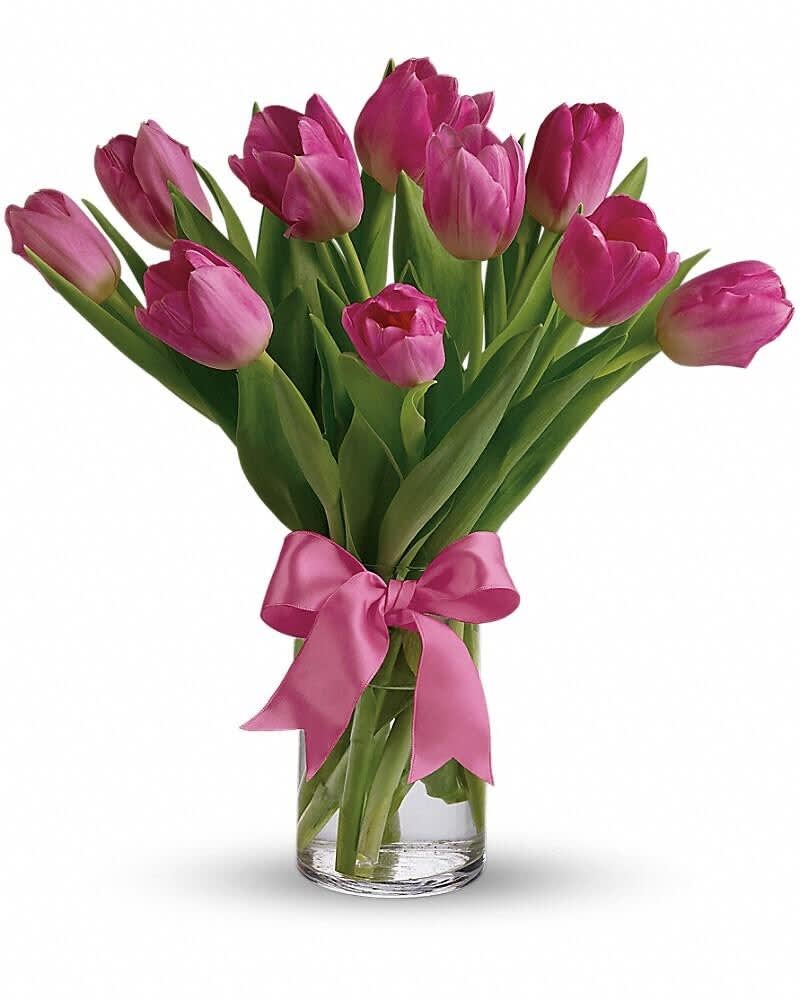Pink tulips arranged in a clear glass vase tied with a pink ribbon bow