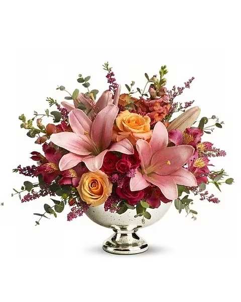 Beauty in Blooms - Just peachy! Pale pink and orange blooms are gathered in a classic silver bowl for a traditional arrangement anyone will treasure. A lovely centerpiece, this elegant bouquet also looks lovely in an entryway or coffee table, brightening the entire room around it! This feminine arrangement includes light orange and hot pink roses, pink asiatic lilies, dark pink alstroemeria, orange snapdragons, delicate pink heather and parvifolia eucalyptus. 