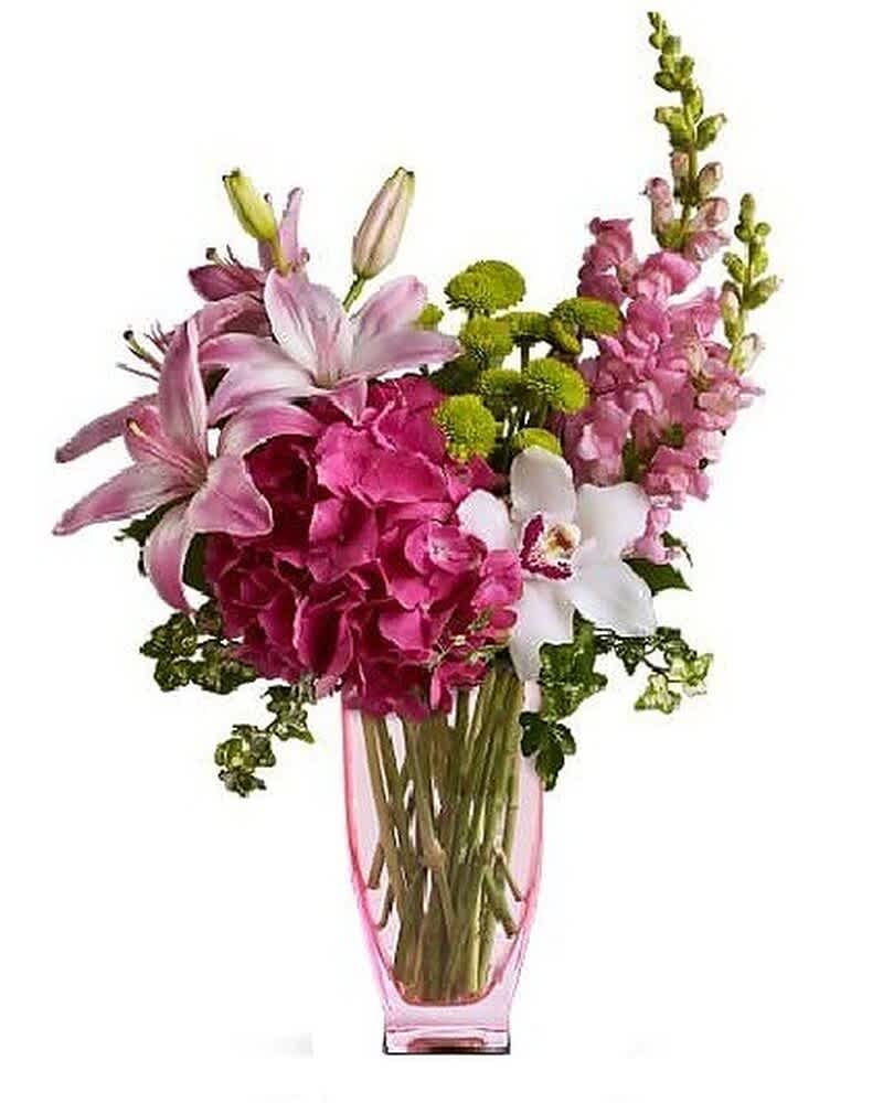 Tall pink and white arrangement with lilies, hydrangea, orchids and mums in a pink glass vase