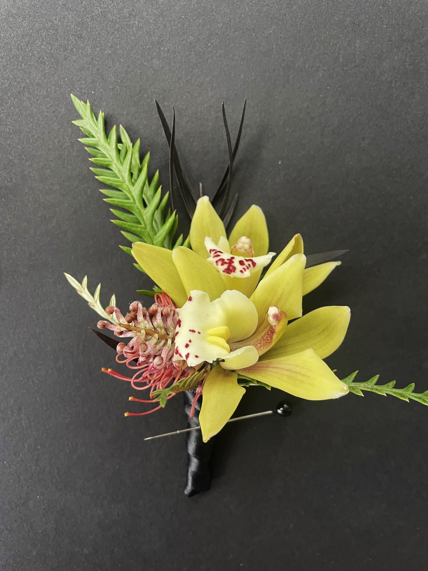 Boutonniere - Boutounnieres  add a touch of elegance and personality to a persons attire and serves as a sophisticated accessory that completes the look for a special occasion.  It consists of a flower or a cluster of flowers accented by foliage and ribbon.  Please specify in the notes any color requests for flowers or ribbon.  Boutonnieres shown here are just some examples, but yours will be designed to be uniquely yours.