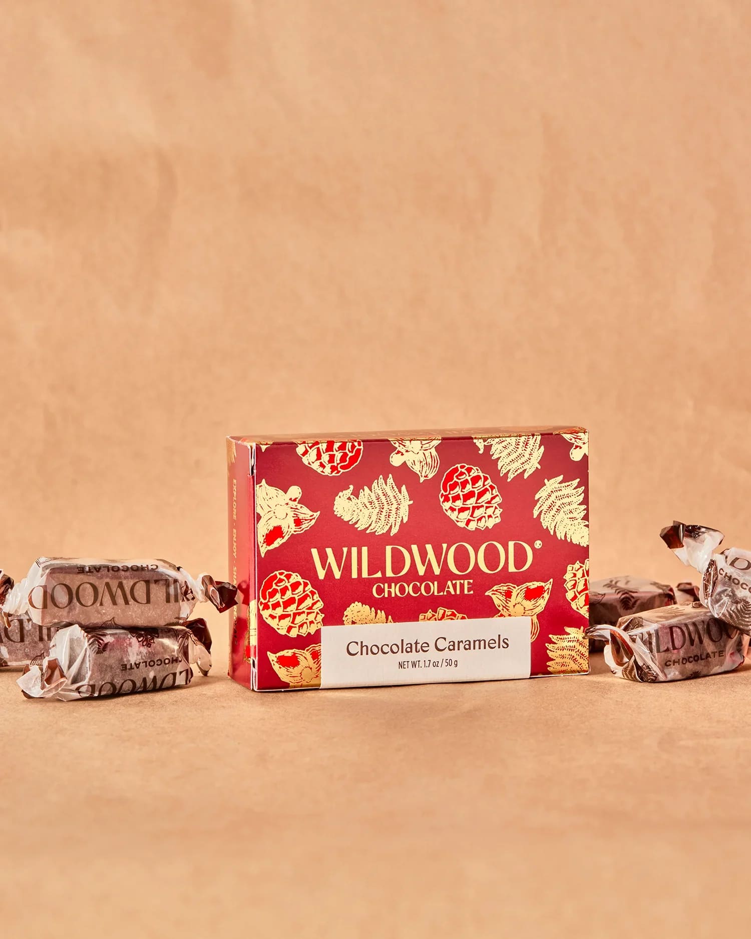 Box of Wildwood chocolate caramels with wrapped candies on a tan background
