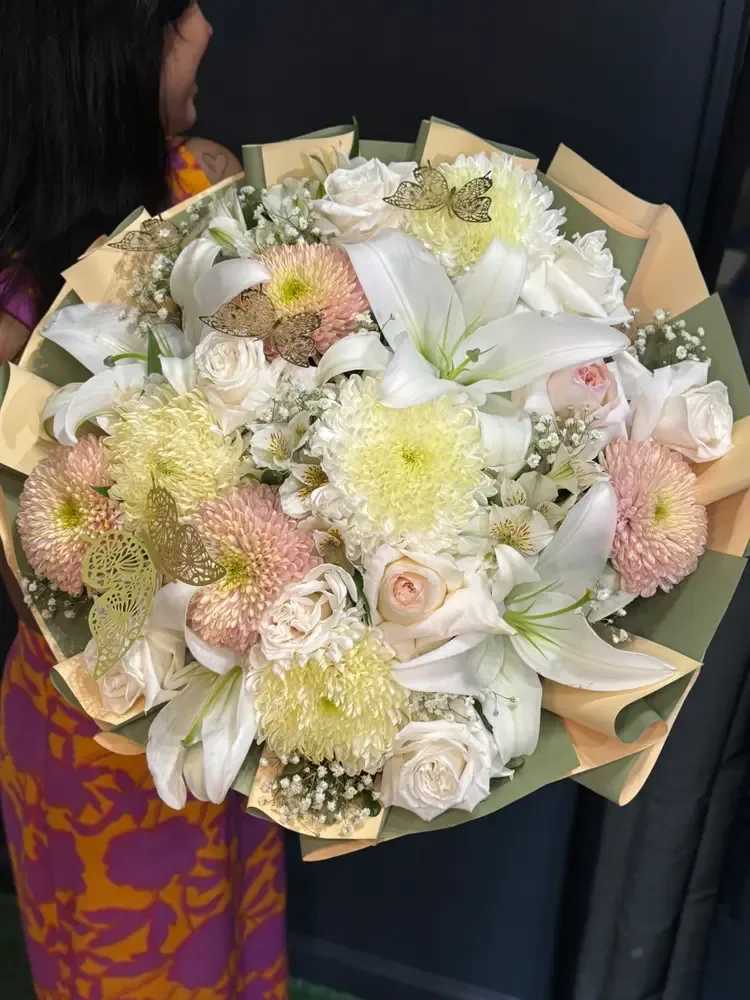 Soft Glow - Soft Glow is a нежный and гармоничный bouquet designed in warm pastel tones, combining white lilies, soft roses, chrysanthemums, and delicate filler flowers. The blend of textures and gentle colors creates a light, airy composition that feels both fresh and comforting. The lilies add elegance and structure, while roses and chrysanthemums bring softness and volume, creating a balanced and inviting design. Subtle accents and layered wrapping complete the bouquet, giving it a refined yet natural appearance. Perfect for birthdays, celebrations, or simply to brighten someone’s day, Soft Glow brings warmth, beauty, and a sense of quiet joy.