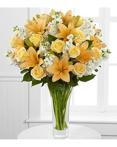 Admiration Luxury Bouquet - Grace and gratitude combine to create a flower bouquet of warmth and beauty that will wish them every caring kindness. Peach Asiatic lilies, cream roses and white stock stems are beautifully arrnanged within a superior flared clear glass vase to offer your special recipient a flower arrangement that conveys your sincere admiration with its sophisticated style. 
