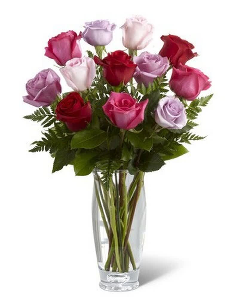 Tall clear glass vase of red, pink, and lavender roses