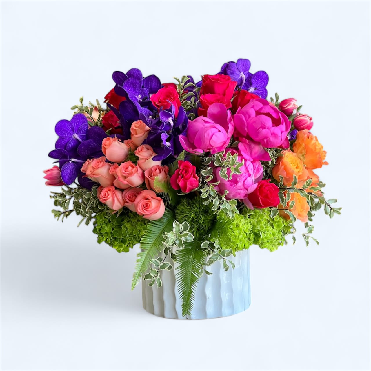 Dragon Lady - This bold floral arrangement features a vibrant mix of hot pink Peonies, Tulips, and Roses, with peach Roses, purple Vanda Orchids, and assorted greenery in a ceramic vase