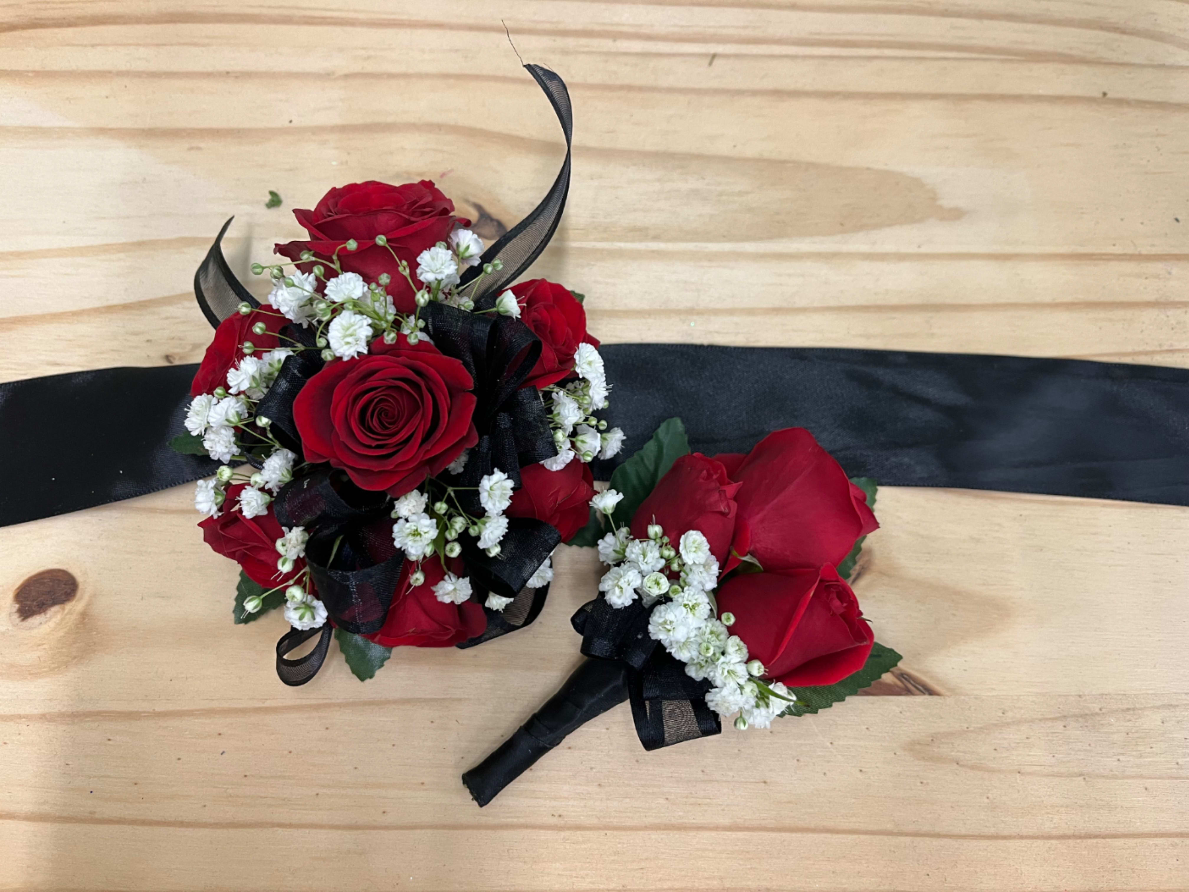 Red Rose Corsage &amp; Boutonnière  - Red rose corsage and boutonniere set accented with baby’s breath for a classic, romantic look. The corsage comes on an adjustable Velcro wristlet, and the boutonniere is attached with a magnet for easy wear. Ribbon color is customizable, please add your choice in the special instructions.