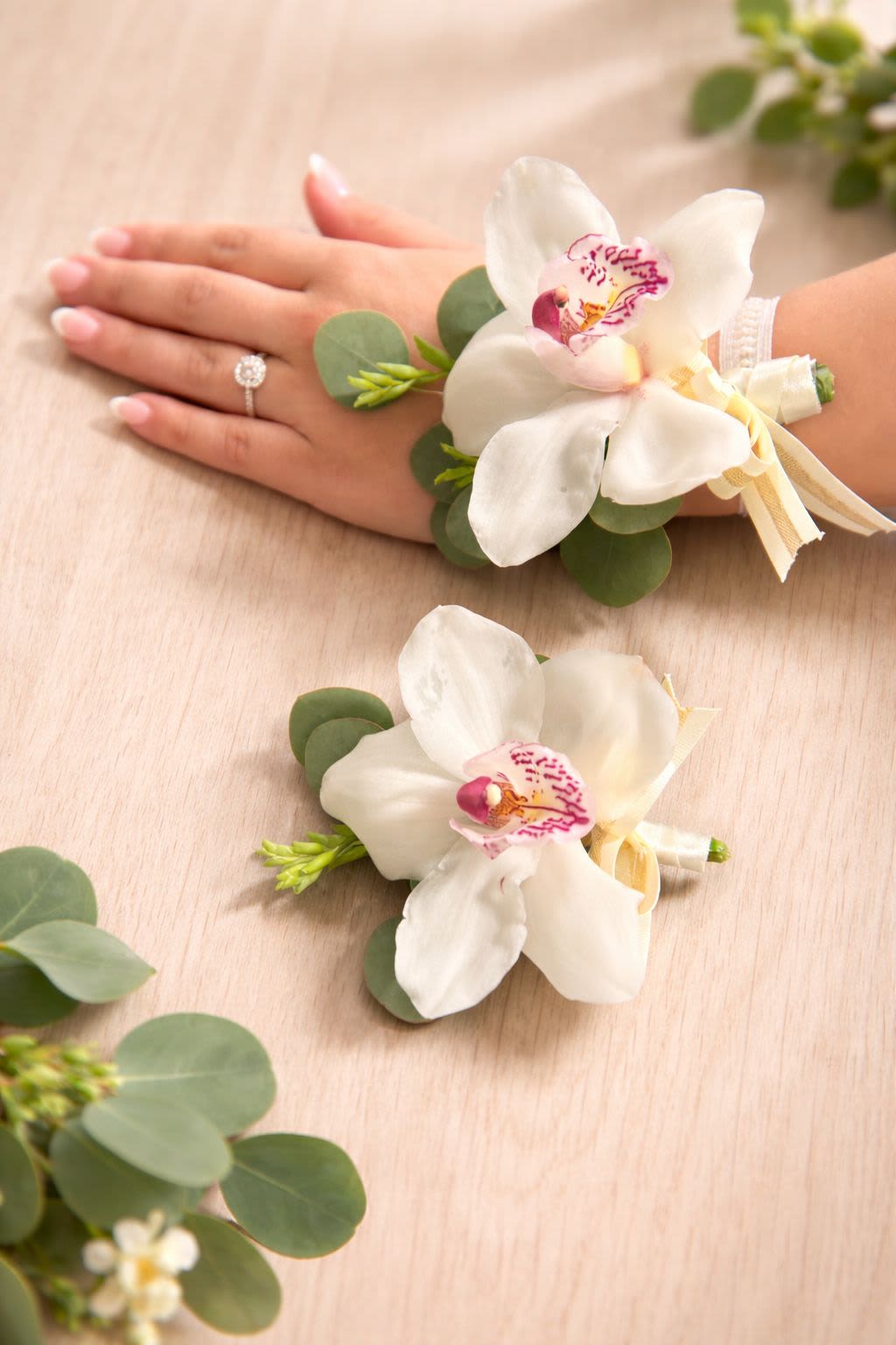 Elegant Orchid Corsage &amp; Boutonniere Set by The House of Flowers - A beautifully coordinated set featuring an elegant orchid wrist corsage and a matching boutonniere. Designed with fresh orchid blooms, delicate greenery, and refined details, this set creates a timeless and sophisticated look for prom, weddings, and special occasions.  Each piece is handcrafted with care to ensure a perfect match and elegant presentation.  Available colors: white, red, green, and yellow. Custom colors are available upon request with advance notice.  Save when you purchase the set. Elegantly packaged in a beautiful presentation box