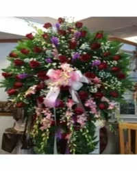 Crimson Orchid &amp; Liatris Tribute Standing Spray - A striking and elegant large standing spray featuring rich red roses, beautifully accented with delicate pink dendrobium orchids and purple liatris for added height and texture. Arranged with lush fresh greenery and finished with a red ribbon bow, this design creates a graceful and dramatic memorial display.  The deep red roses symbolize love and respect, while the orchids and liatris add touches of admiration, strength, and remembrance, making this arrangement a heartfelt and meaningful tribute to honor a cherished life
