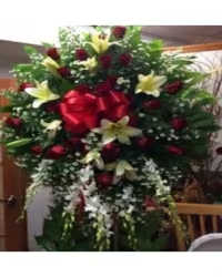 Crimson &amp; Ivory Tribute Standing Spray - A striking and elegant large standing spray designed to honor a loved one with beauty and grace. This stunning tribute features rich red roses, fragrant white oriental lilies, and delicate white dendrobium orchids, artfully arranged with lush fresh greenery for a full and dramatic display.  The bold contrast of red and white flowers symbolizes love, respect, and remembrance, creating a meaningful and heartfelt expression of sympathy. Displayed on a standing easel, this arrangement offers a beautiful and dignified way to celebrate and honor a cherished life.