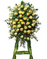 Golden Remembrance Rose Standing Spray - A radiant and elegant all-yellow rose standing spray designed to honor a life remembered with warmth, friendship, and cherished memories. This beautiful tribute features fresh yellow roses thoughtfully arranged with lush greenery to create a full and graceful display on a standing easel.  Yellow roses symbolize friendship, remembrance, and a celebration of life, making this arrangement a meaningful expression of sympathy and respect.  Available in three sizes to suit your tribute:  Standard: 50 Roses  Deluxe: 75 Roses  Premium: 100 Roses  Each spray is carefully handcrafted to create a stunning and heartfelt memorial display