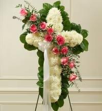 Serene Pink Cross Spray - A tender and elegant standing cross arrangement designed to convey love, remembrance, and sympathy. This display features a solid cross of pristine white mums, accented with a cross break of soft pink roses and delicate white asters or baby’s breath. Lush fresh greens frame the design, creating a balanced, graceful, and heartfelt tribute.