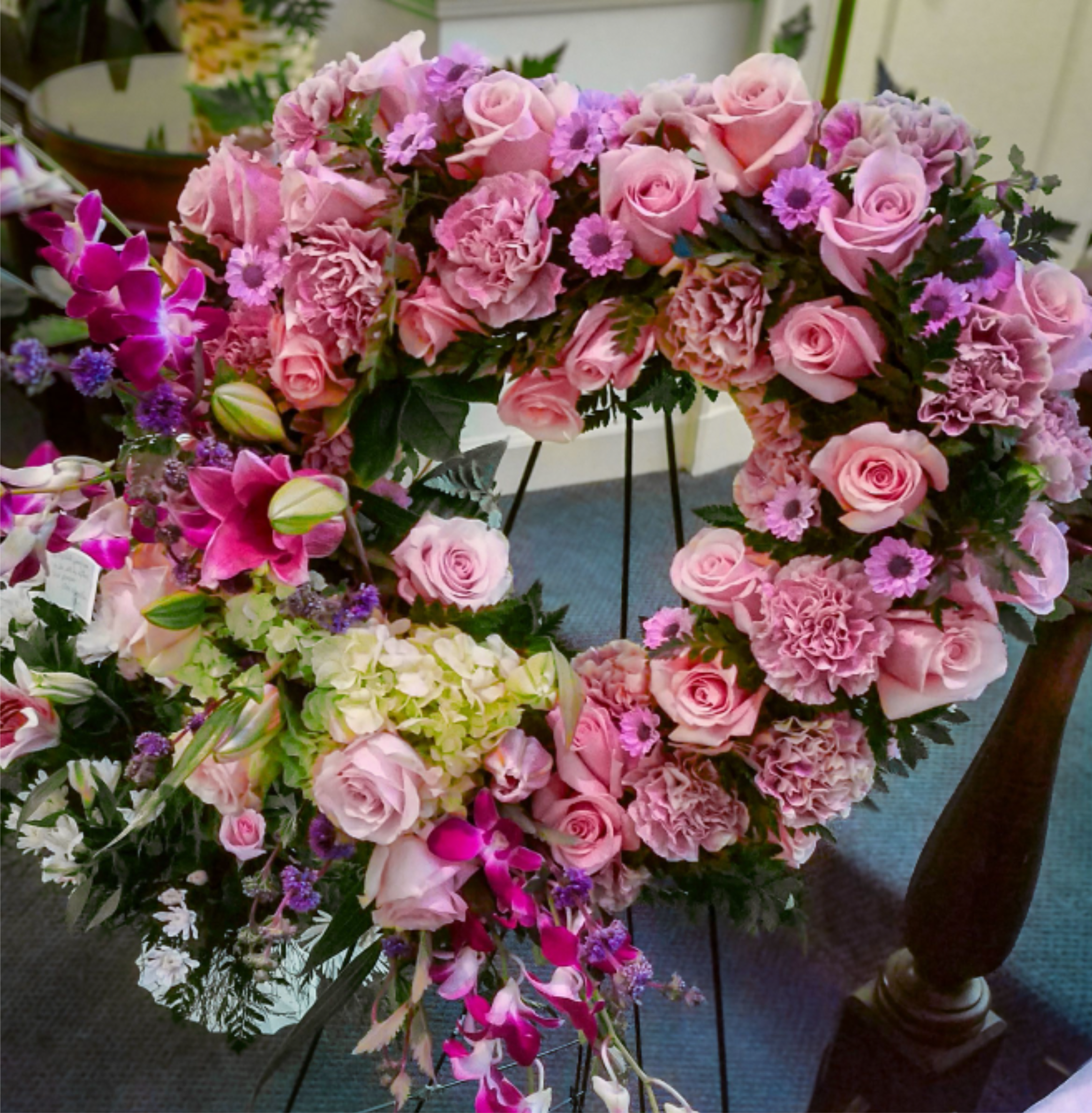 'Beautiful Maxine' By Madison's Flowers - Presenting a stunning heart shaped standing spray, crafted with love and care. This beautiful arrangement features, Pink Roses, pink Carnations, Dendrobium Orchids, White Hydrangeas, and Stargazer Lilies. Each flower is carefully selected to celebrate the unique essence and true beauty of your loved one. Offering a heartfelt tribute that resonates deeply. If you're seeking a way to honor someone special, this exquisite piece serves as a touching reminder of their individuality and warmth they bring to your life.