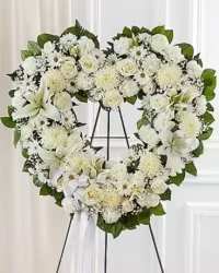 Eternal Love Open Heart Spray - A graceful open heart-shaped sympathy spray designed to symbolize everlasting love and remembrance. This elegant tribute features a delicate blend of white spray roses, white roses, white carnations, white lilies, white daisies, baby’s breath, and white cremon mums, beautifully arranged with fresh greenery to create a soft and full display.  Finished with a white ribbon bow, this heartfelt design offers a peaceful and meaningful expression of sympathy, honoring a cherished life with purity, love, and respect.