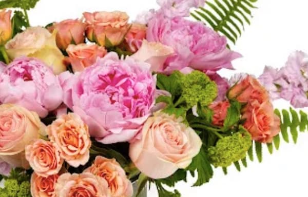 Pastel bouquet with pink peonies and peach roses accented by fern fronds