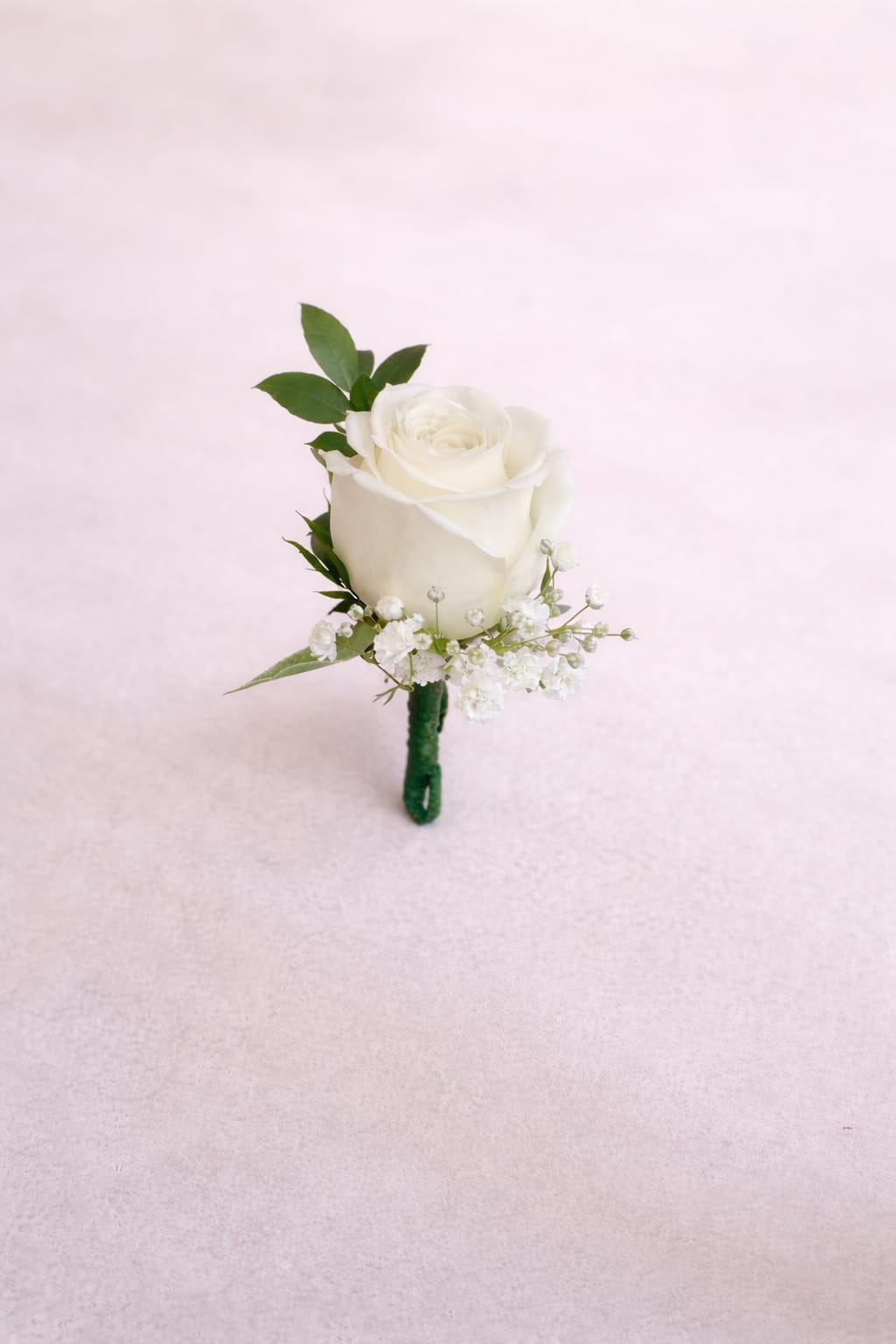 Rose boutonnière  - Single white rose boutonnière with greenery and delicate filler, stem neatly wrapped in green tape. Ribbon can be added for additional cost. We will contact you to confirm color choice for rose. 