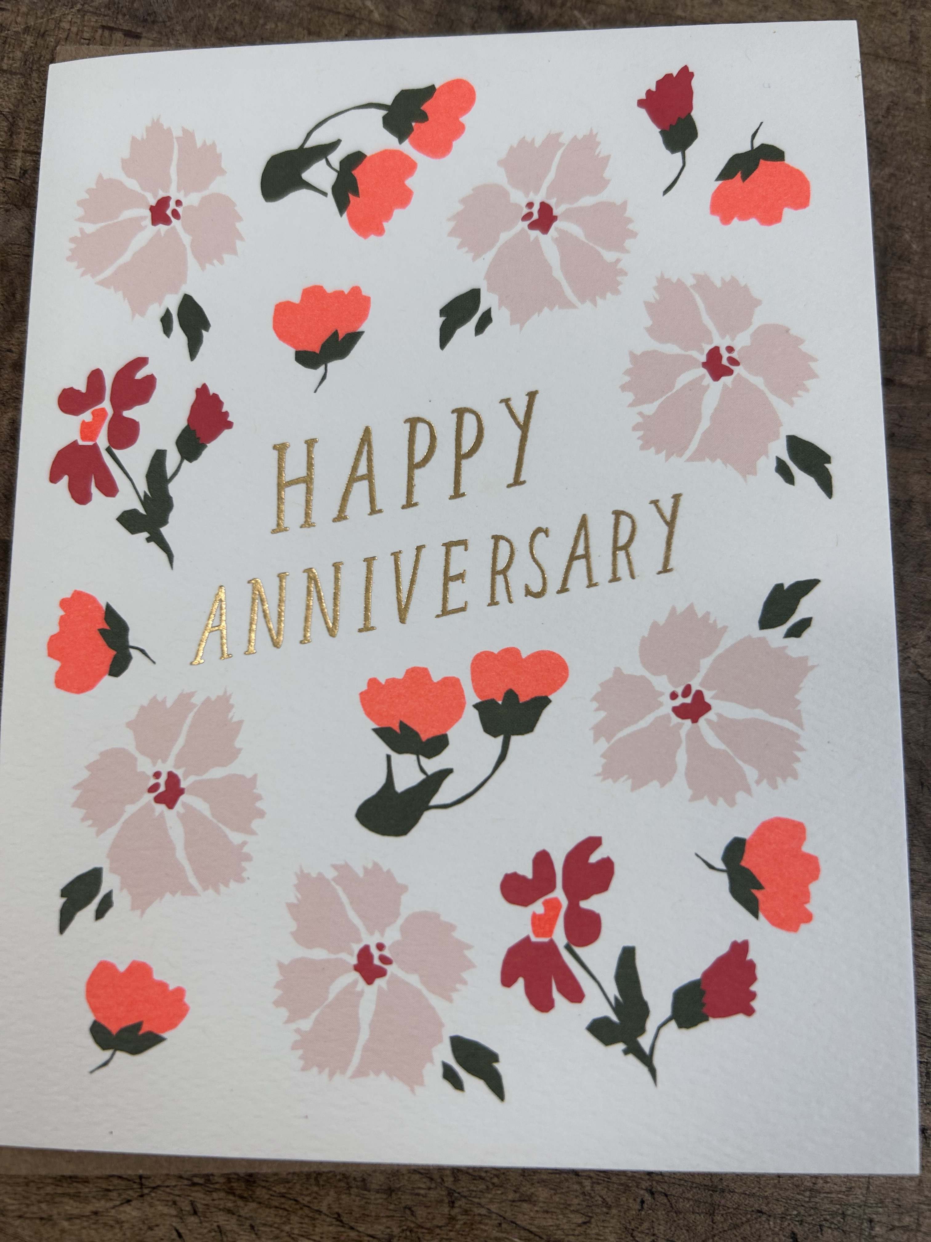 Happy anniversary greeting card with pink and red floral illustrations and gold lettering