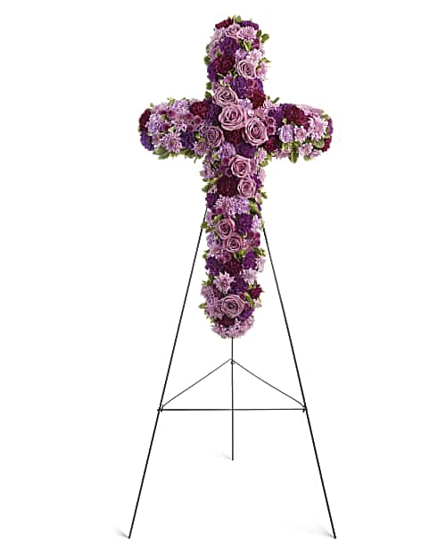 Deepest Faith - A breathtaking standing cross of majestic purple and lavender blooms remembers and honors the departed with a meaningful and moving expression of faith, admiration and divine love. Gorgeous blooms such as lavender roses and carnations, and chrysanthemums of lavender and deep purple create a religious display ideal for a funeral or memorial service. Orientation: One-Sided