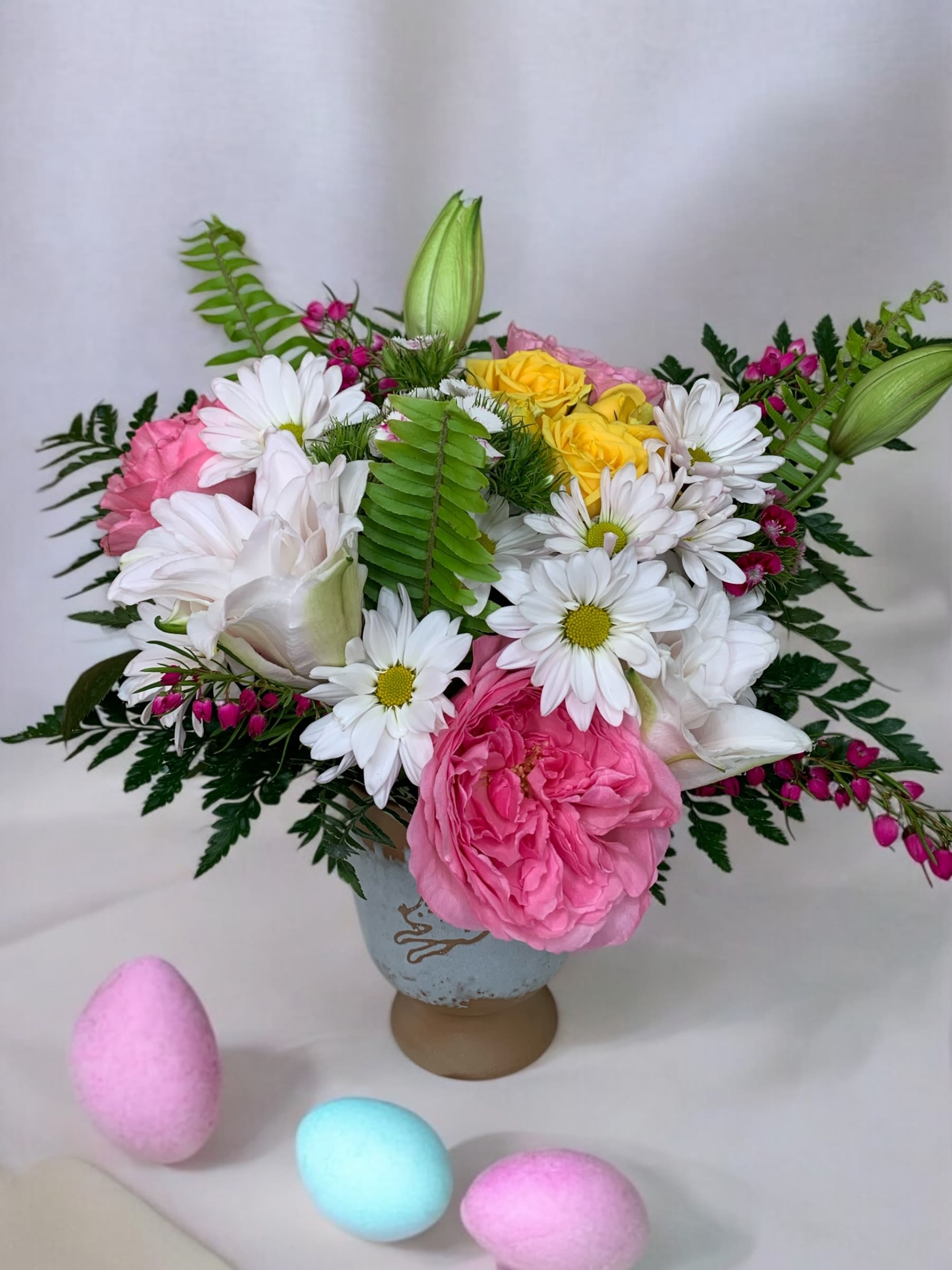 Pink and white flower arrangement with daisies and roses in a vase