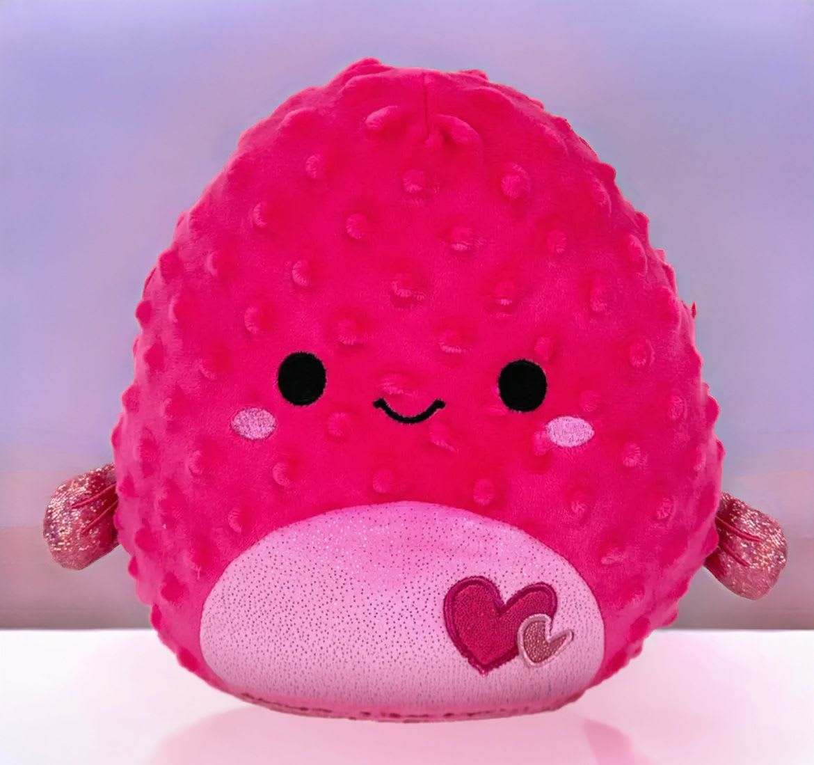 Bright pink heart-themed plush character toy with a smiling face and textured body.