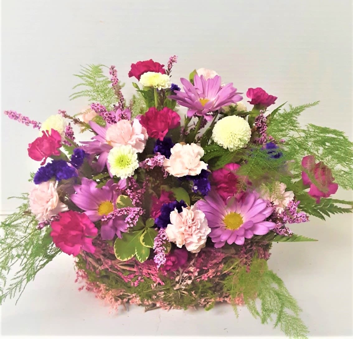 Mountain Rattan Basket Small - This small colorful rattan basket is full of long lasting, colorful flowers for a touch of cheer, which includes daisies, mini carnations and assorted button flowers. 