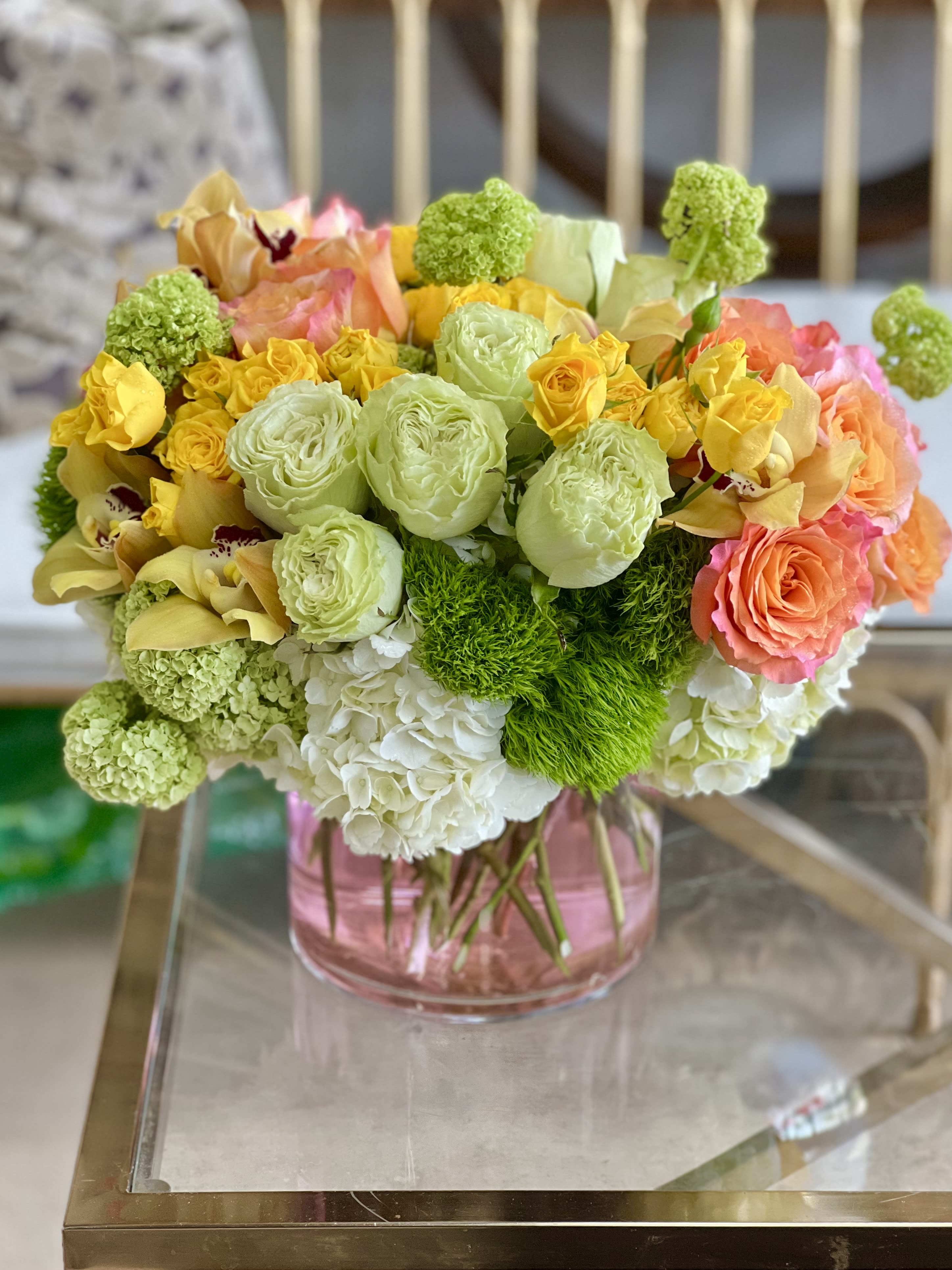 Summer Days - A bright, cheerful mix of Roses, Dianthus, Hydrangea, and Cymbidium Orchids, in a clear glass vase